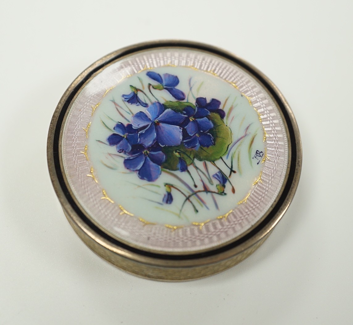 An early 20th century French engine turned white metal and guilloche enamel circular compact with cover, decorated with flowers, 49mm.